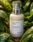 Azurlis Face & Body Elixir bottle with a silver pump against a green leafy background