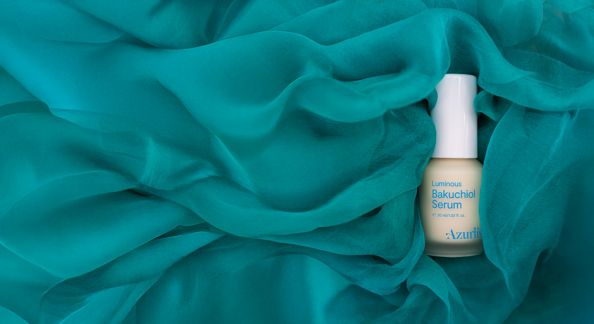 Luminous Bakuchiol Serum on teal coloured fabric.